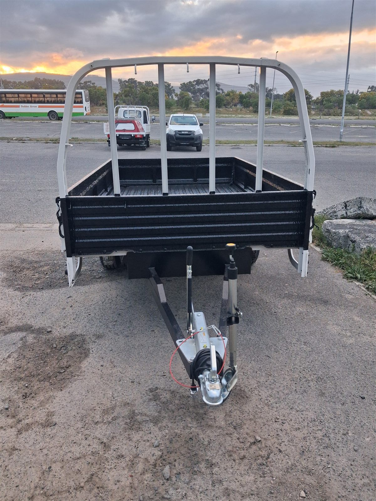 Front view of trailer showing hitch, jockey wheel and headboard at sunset